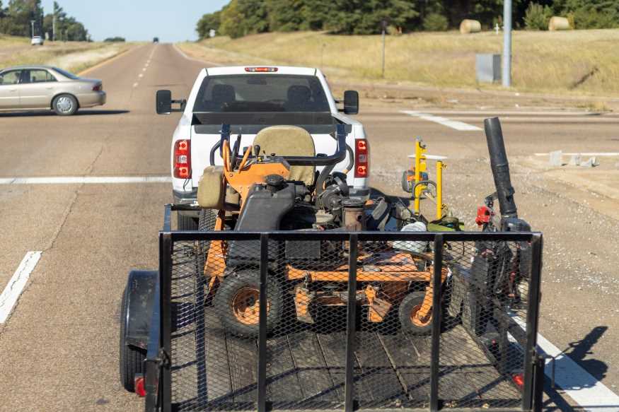 Commercial truck towing a lawnmower