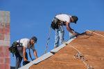 dos-contratistas-hacen-su-trabajo-arriba-del-techo-alto-y-peligroso-de-una-casa